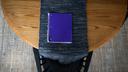 A purple notebook on a dining room table.