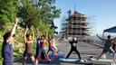 People in yoga poses in front of Reading Pagoda, which is surrounded by scaffolding. People in yoga poses in front of Reading Pagoda, which is surrounded by scaffolding.