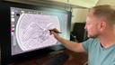 Medallic artist Eric David Custer at his workstation, showing his design for the tails side of the semiquincentennial dime on a computer screen.