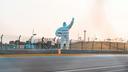 The “Michelin Man” positioned near a racetrack.