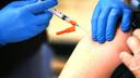 A health care worker administers a COVID-19 vaccine.