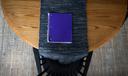 A purple notebook on a dining room table.