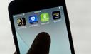 FanDuel, DraftKings, and other online gambling apps are displayed on a phone.