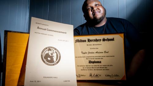 Taylor Bost, 28, with his diploma and commencement program Taylor Bost, 28, with his diploma and commencement program