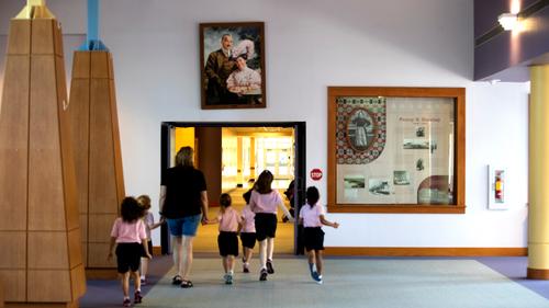 A group passes under a portrait of Milton and Catherine Hershey in Fanny Hershey Memorial Hall at the Milton Hershey School A group passes under a portrait of Milton and Catherine Hershey in Fanny Hershey Memorial Hall at the Milton Hershey School