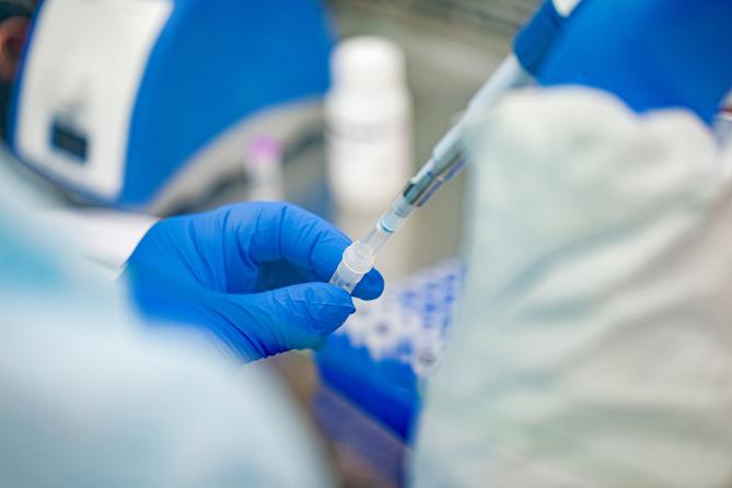 A syringe is inserted into a vial. A syringe is inserted into a vial.