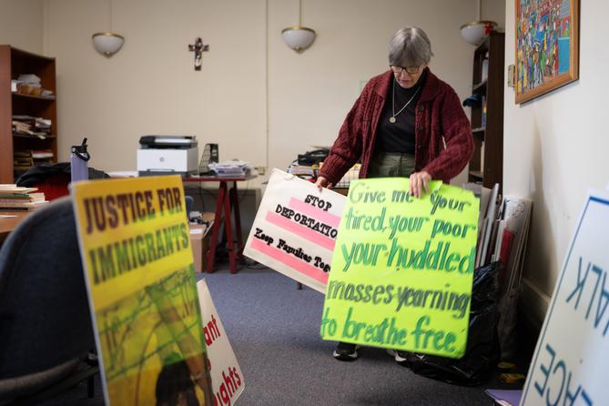 Sister Anne McCarthy with the Benedictine Sisters of Erie looks through her signs protesting President Donald Trump’s nationwide immigration crackdown. Sister Anne McCarthy with the Benedictine Sisters of Erie looks through her signs protesting President Donald Trump’s nationwide immigration crackdown.