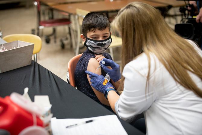 A child receives a vaccine from a nurse