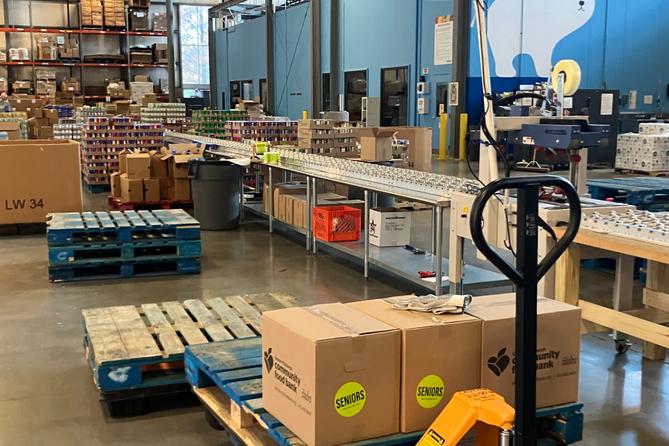 The senior food box assembly line at the Greater Pittsburgh Community Food Bank. Each package receives a package which includes canned fruits, vegetables, and beans, pasta, cereal, juice, and cheese.