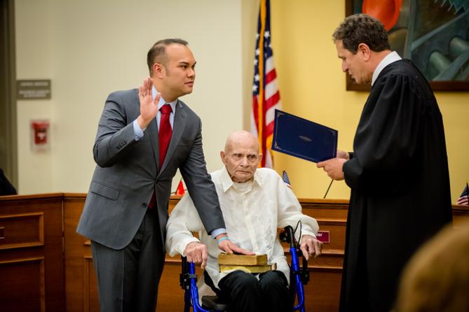 Urscheler takes the oath of office in January 2018, placing his hand on a Bible resting on his 90-year-old father’s lap. Urscheler takes the oath of office in January 2018, placing his hand on a Bible resting on his 90-year-old father’s lap.