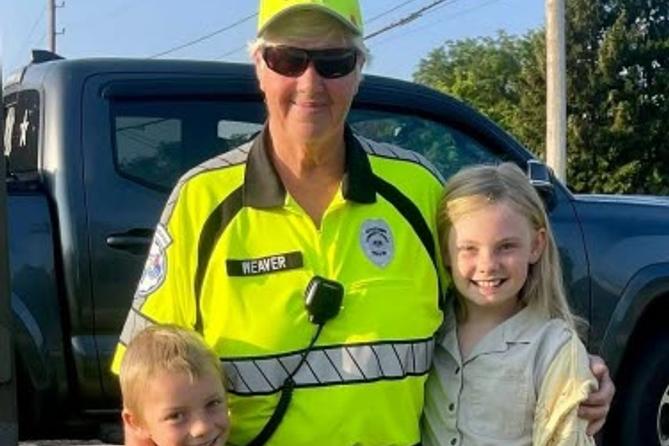 Crossing guard Jan Weaver hugs two children Crossing guard Jan Weaver hugs two children