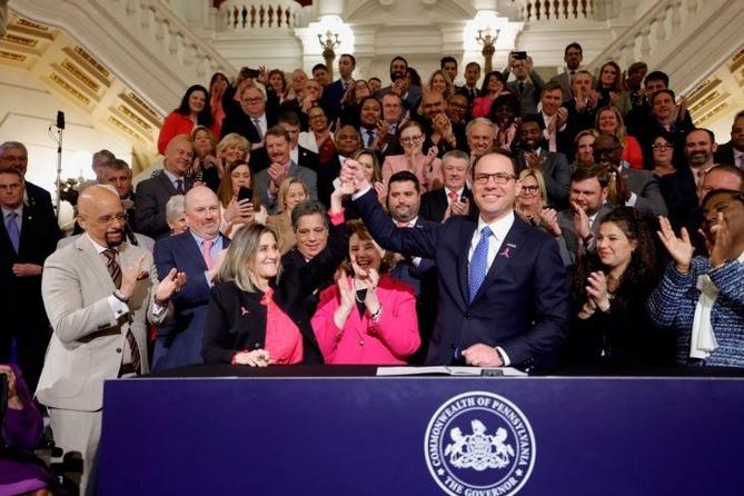 Pa. Gov. Josh Shapiro holds up Senate President Pro Tempore Kim Ward's hand as he signs the first bill of his tenure. Pa. Gov. Josh Shapiro holds up Senate President Pro Tempore Kim Ward's hand as he signs the first bill of his tenure.