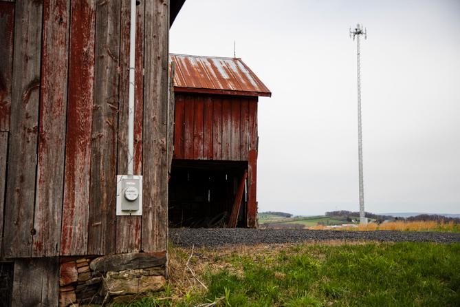 Red barn in rural Pennsylvania with a cellular tower in the background Red barn in rural Pennsylvania with a cellular tower in the background
