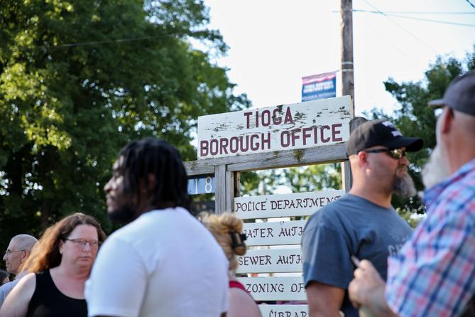 People stand in front of the Tioga borough office sign. People stand in front of the Tioga borough office sign.